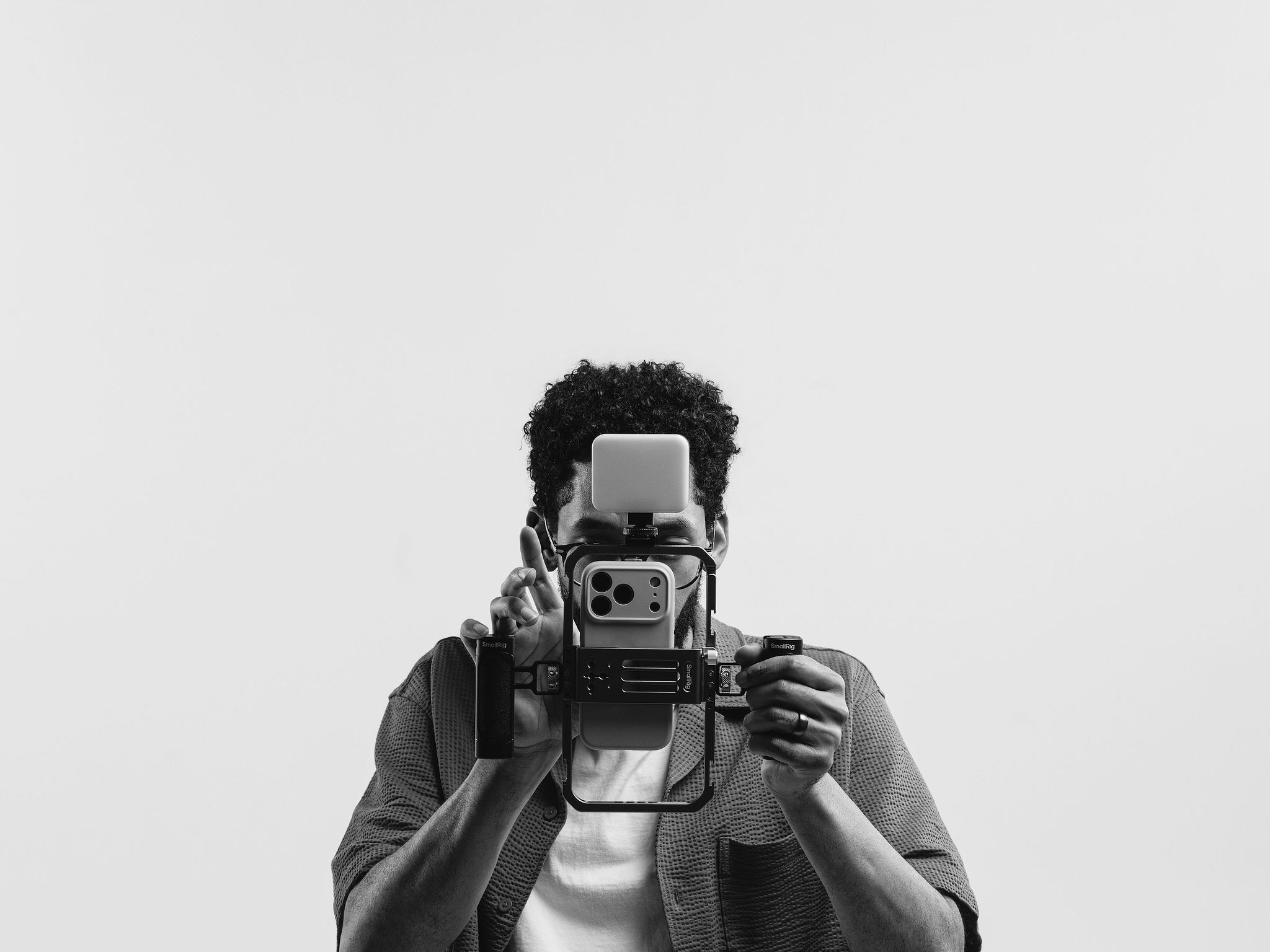 Shane filming with a phone camera rig held up to his face