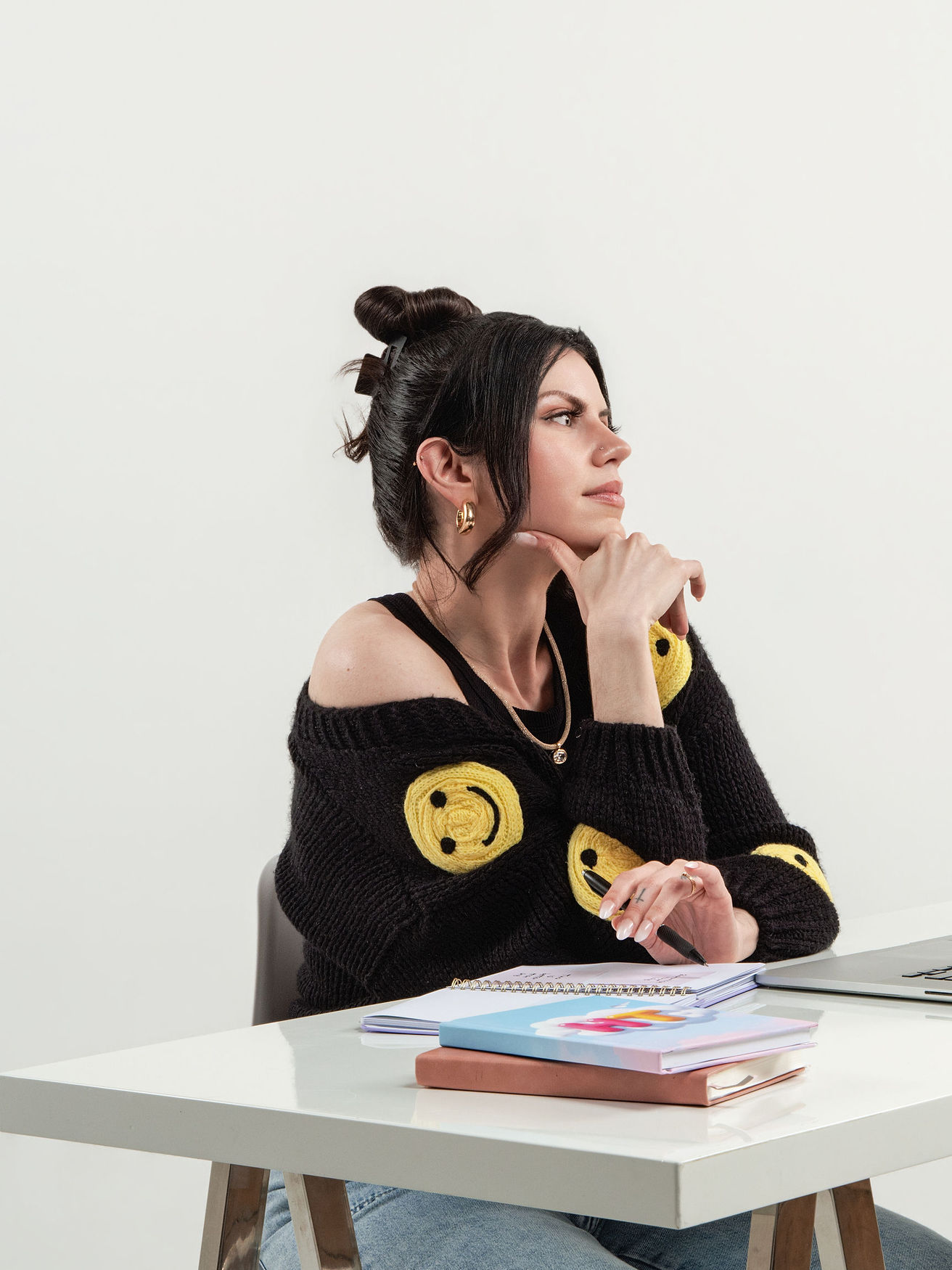 Meggan at her desk with a laptop, chin resting on her hand